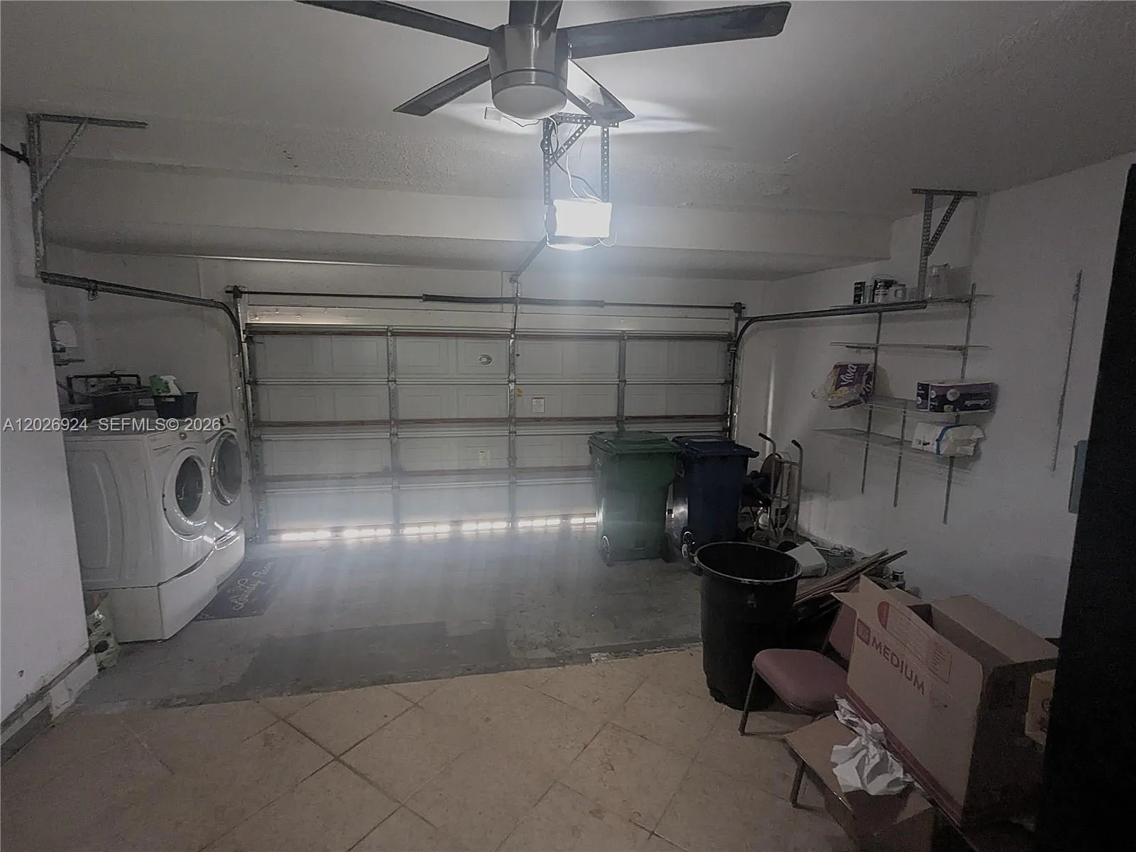 Garage with a ceiling fan for added comfort, offering space for two cars and a convenient washer-and-dryer area — practical and ready for everyday use