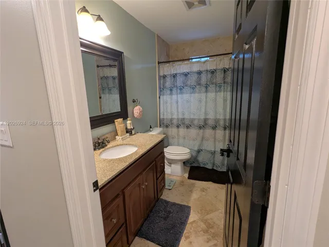 Second full bathroom featuring a granite-top vanity, modern lighting, and a clean tub/shower combo, offering a practical and well-maintained space for daily use.