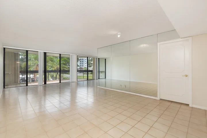 Large living Room with balcony of palm tree top views facing south west. Unit on second floor.