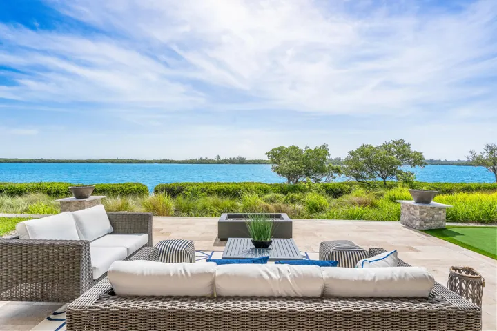 Expansive outdoor patio with fire features and wide water views.