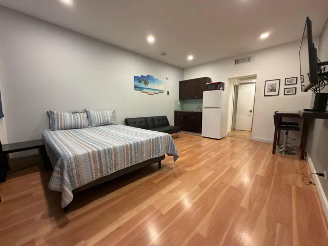 Studio apartment on fist floor near pool with laminate flooring and recessed lights.