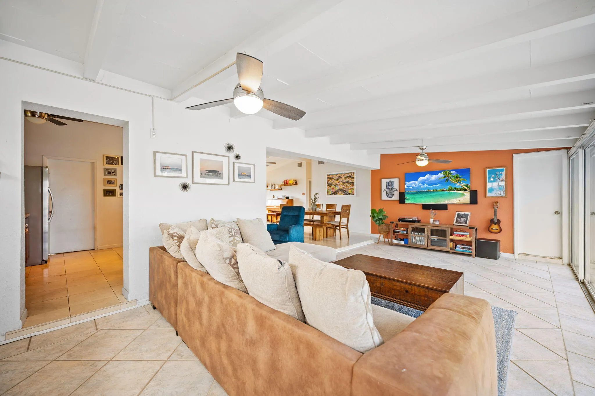 Florida room with entry to kitchen, door to primary suite and opening to dining/living