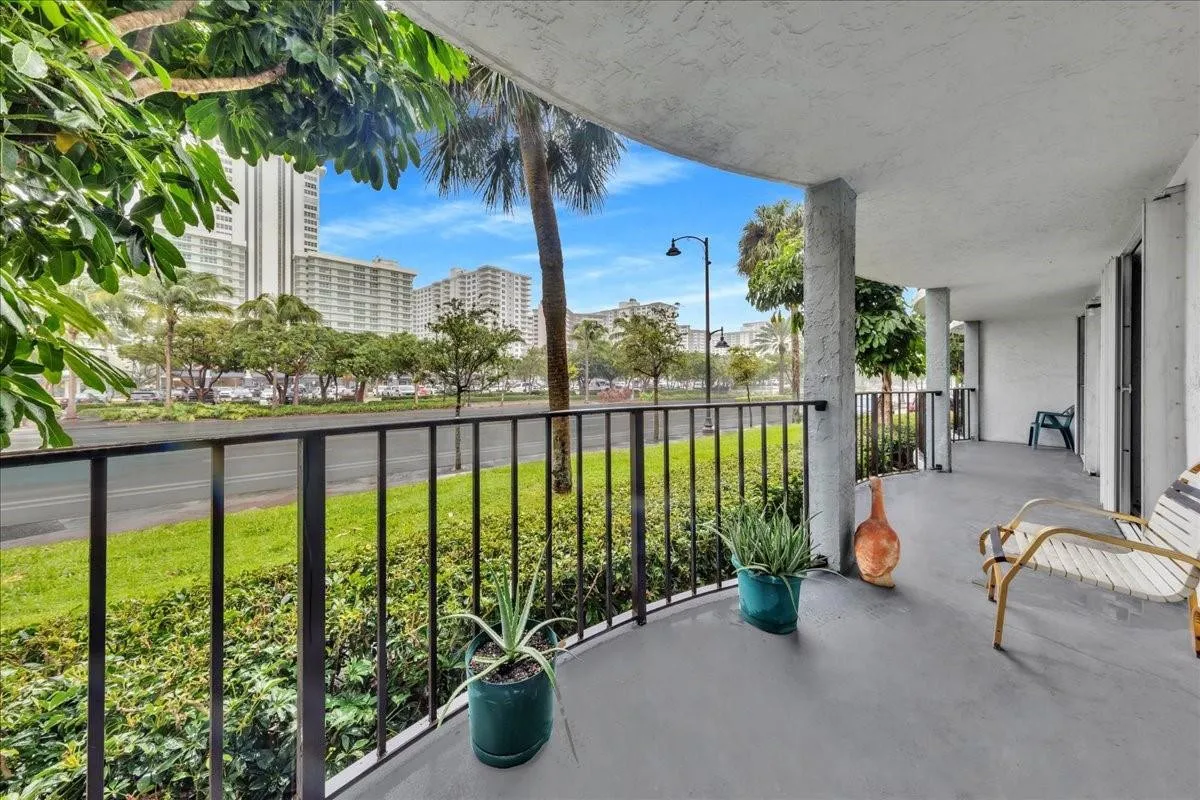 Covered balcony overlooking lush landscaping and Ocean Boulevard in Fort Lauderdale condo.