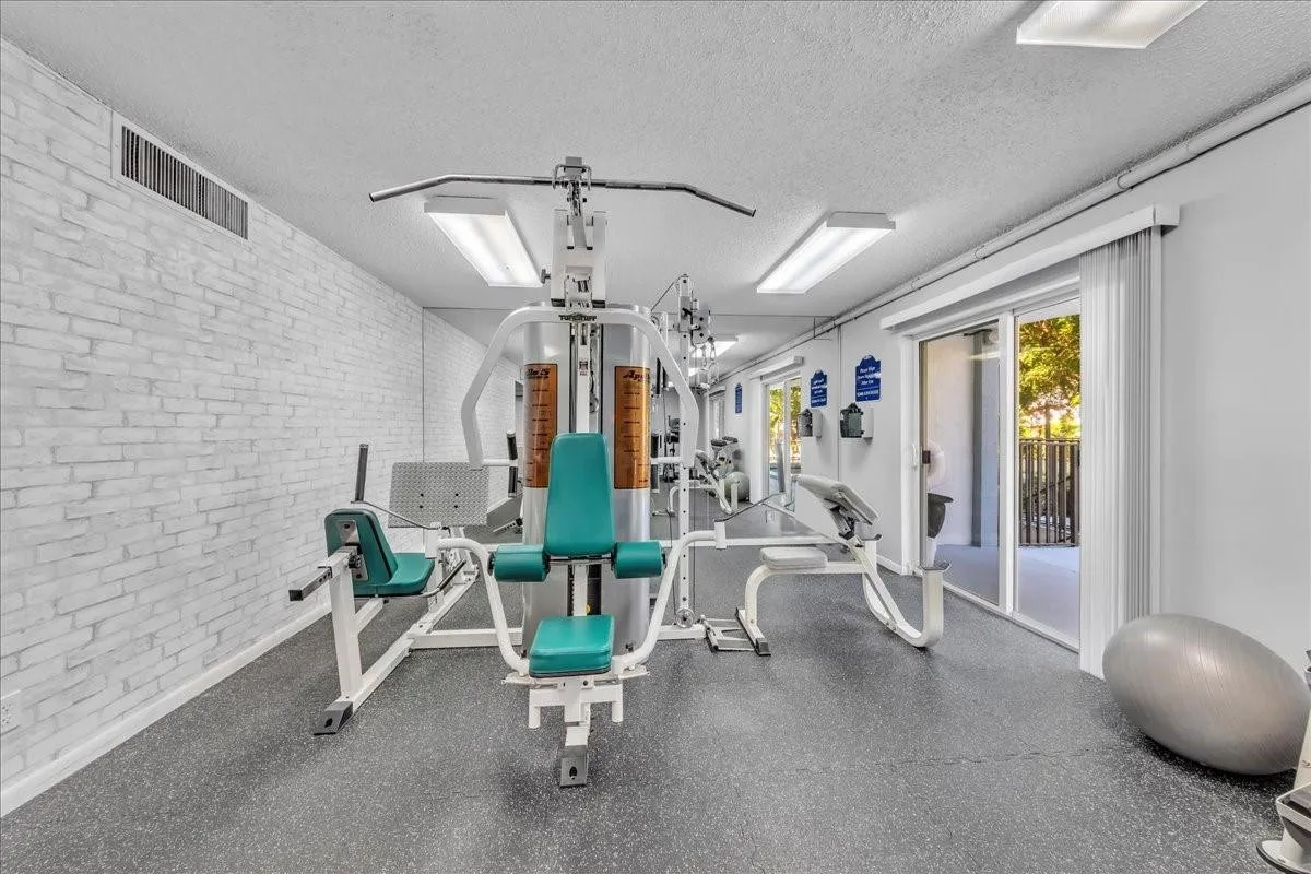 Spacious exercise room with mirrored walls and modern equipment in coastal Fort Lauderdale condo community.
