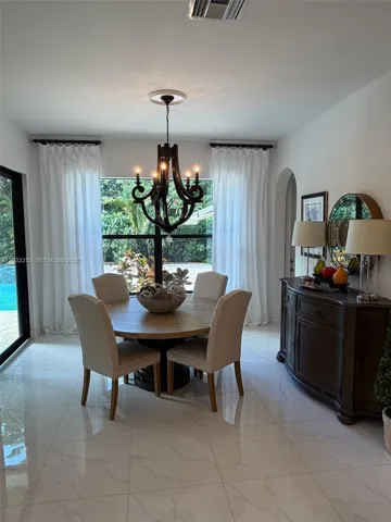 DINING AREA NEXT TO KITCHEN OVERLOOKING GARDEN AND POOL DECK.
