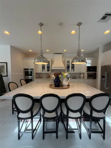 CHEF'S DREAM KITCHEN. 9'X6' ISLAND, CUSTOM HOOD, GLASS CABINET DOORS, SOFT CLOSE, PREMIUM APPLIANCES, DOUBLE OVEN, MIELE ESPRESSO COFFEE MACHINE, DESIGNER LIGHT PENDANTS, QUARTZ COUNTER TOP.