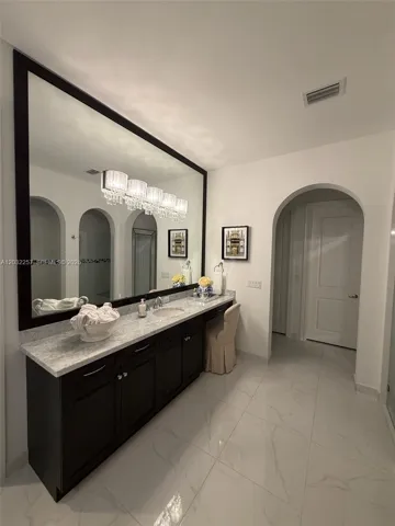 LARGER VANITY WITH DESIGNER CRYSTAL LIGHTING AND MARBLE COUNTER TOP.