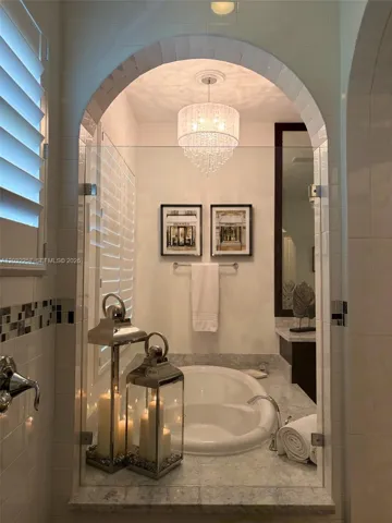 PRIMARY BATHROOM VIEW FROM THE WALK IN SHOWER. PLANTATION SHUTTERS INSTALLED ON WINDOWS.
