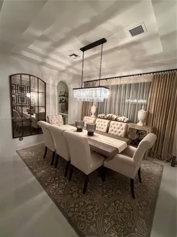 MAIN DINING ROOM WITH DOUBLE TRAY CEILING, DECORATED WITH A DESIGNER GLASS CHANDELIER