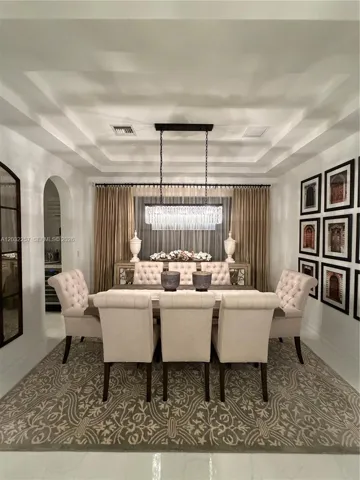 MAIN DINING ROOM WITH ARCHED ENTRYWAY LEADING TO KITCHEN AREA.