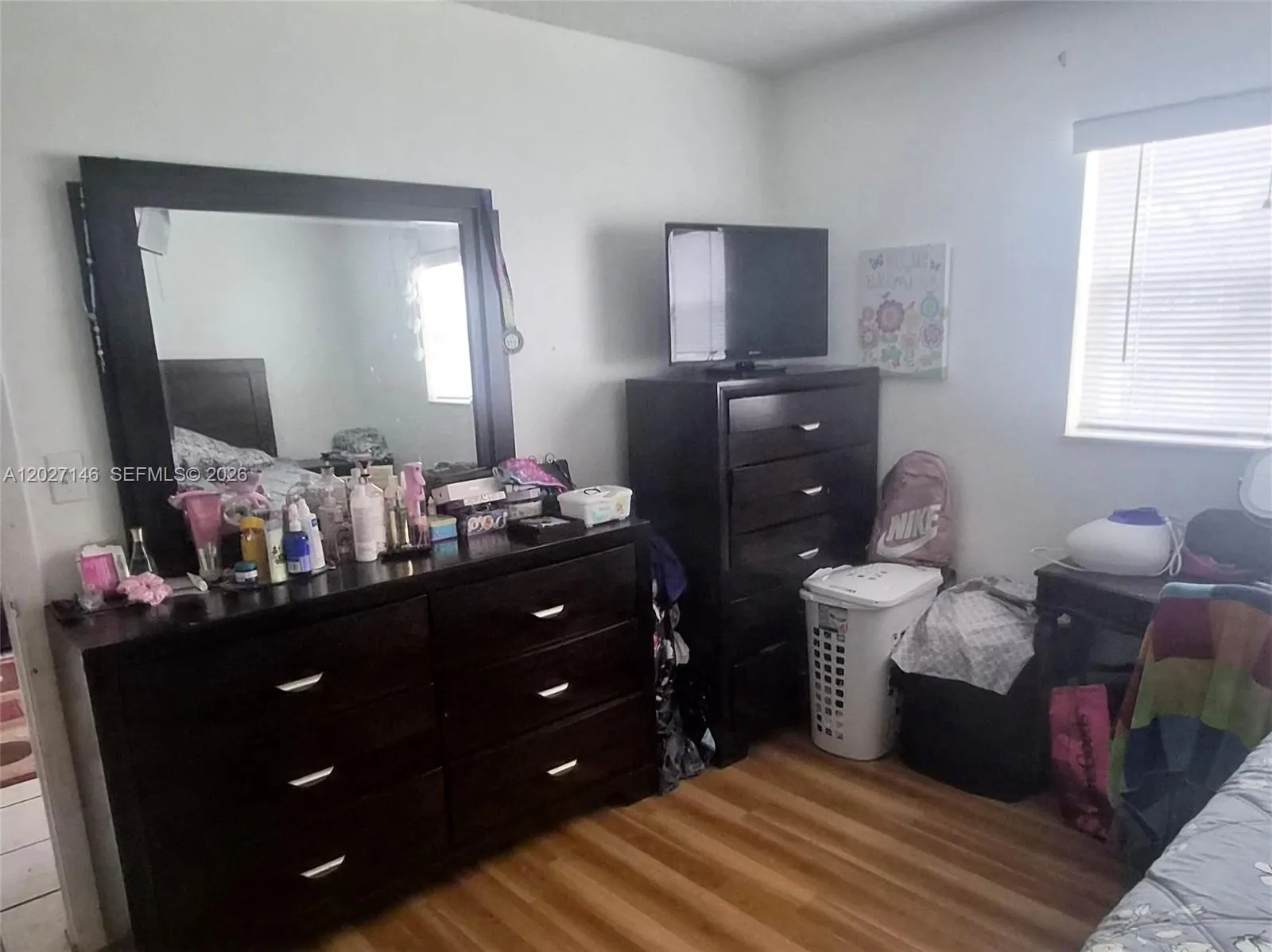 Alternate view of the spacious bedroom showing its flexible layout, with ample room to comfortably accommodate a large dresser set and a work-from-home desk.