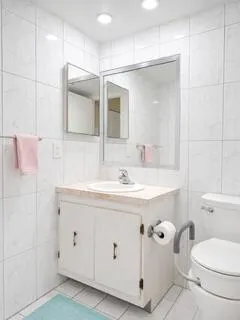 Ensuite bathroom includes floor to ceiling tile with recessed lighting.