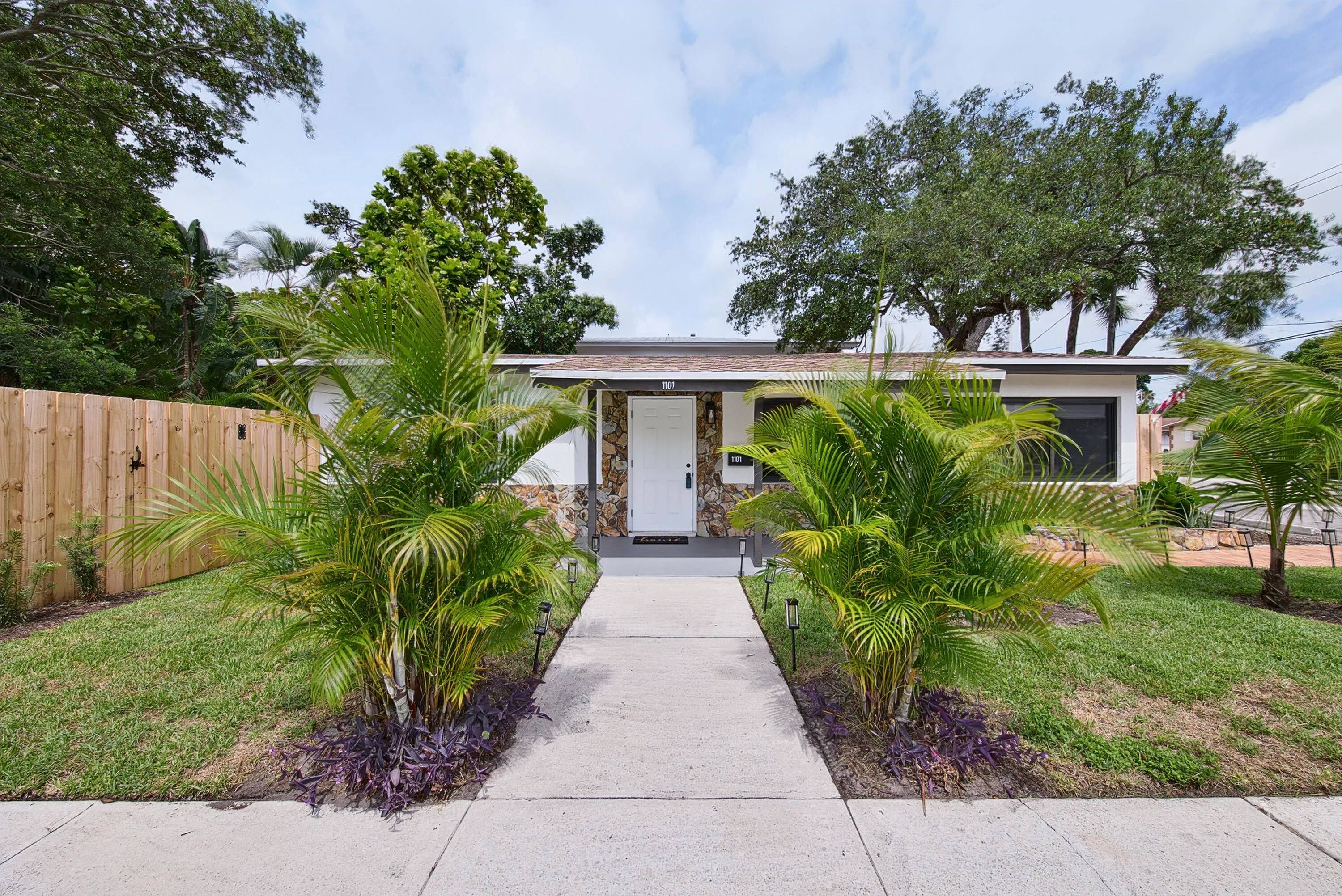 Entrance to front door framed by areca palms