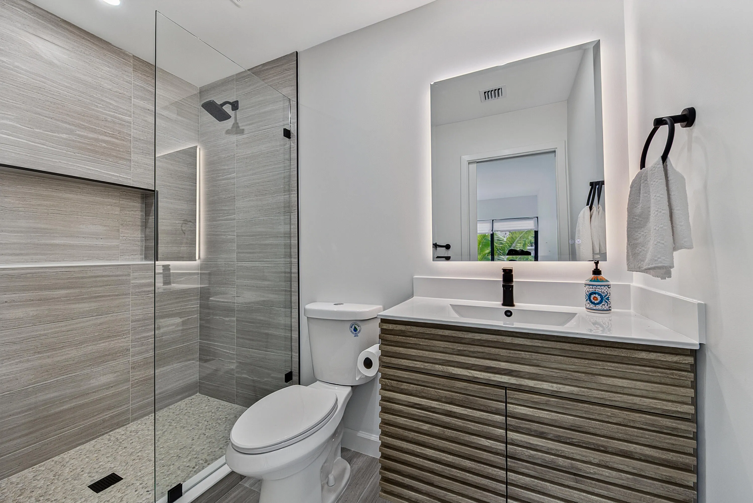 Lighted oversized mirror Shower features niche and lovely shower an sink