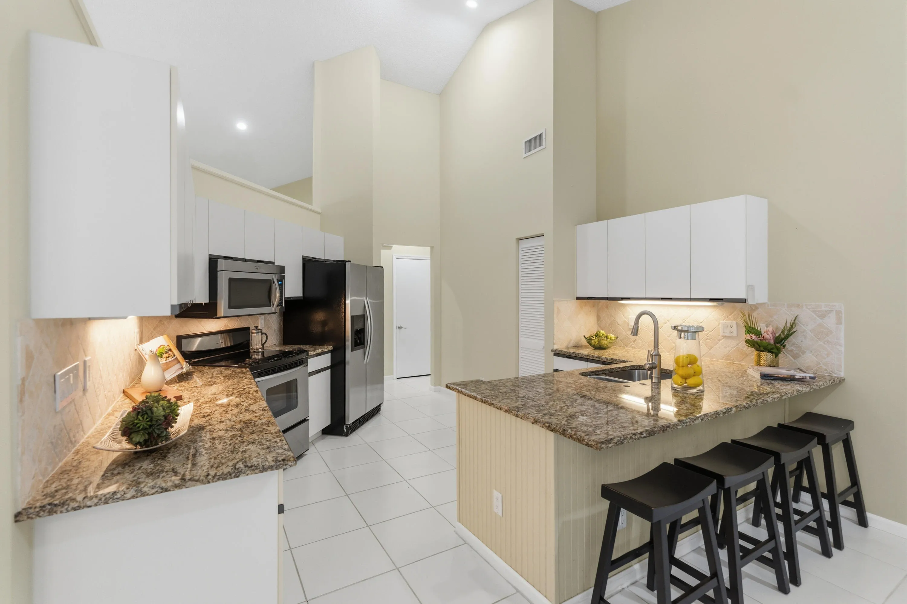 Kitchen with granite countertops, stone backsplash, stainless appliances, pantry and breakfast nook.