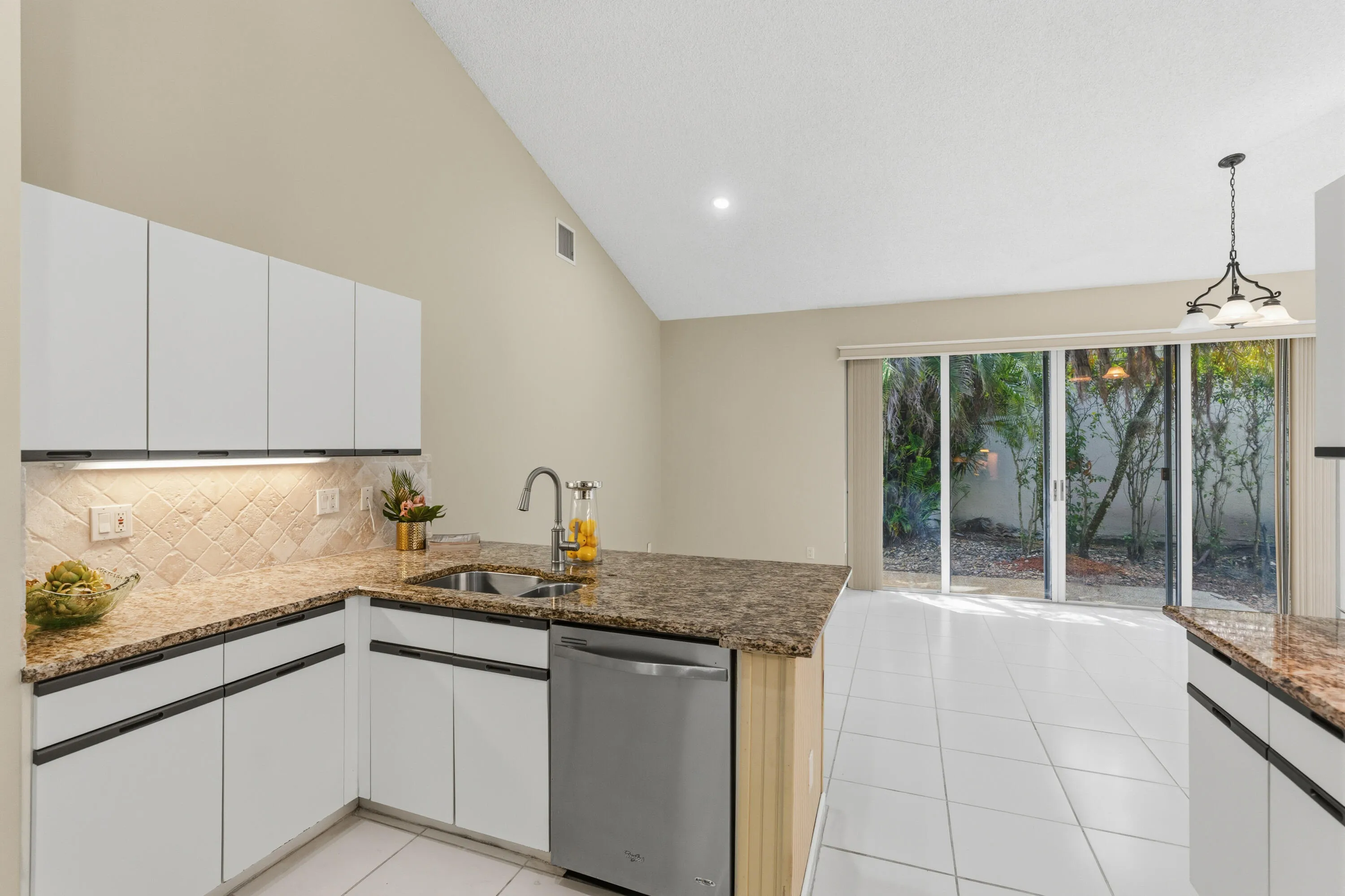 Kitchen with granite countertops, stone backsplash, stainless appliances, pantry and breakfast nook.