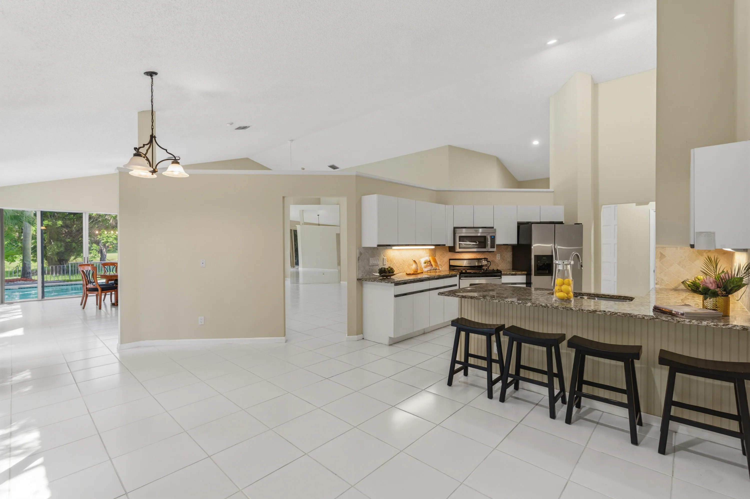 Kitchen with granite countertops, stone backsplash, stainless appliances, pantry and breakfast nook.