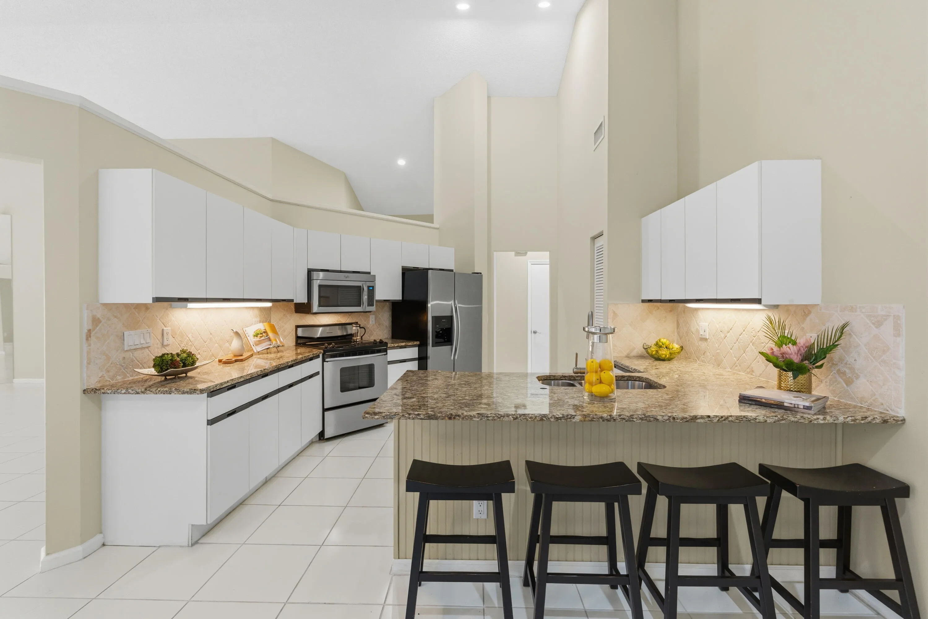 Kitchen with granite countertops, stone backsplash, stainless appliances, pantry and breakfast nook.