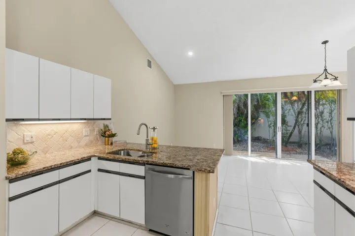 Kitchen with granite countertops, stone backsplash, stainless appliances, pantry and breakfast nook.