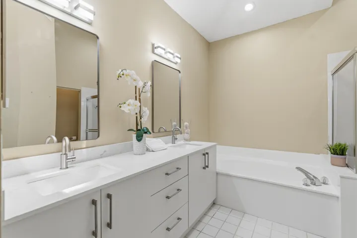 Renovated Primary bathroom. New vanity with quartz countertops, under mount sinks, new lighting and fixtures.