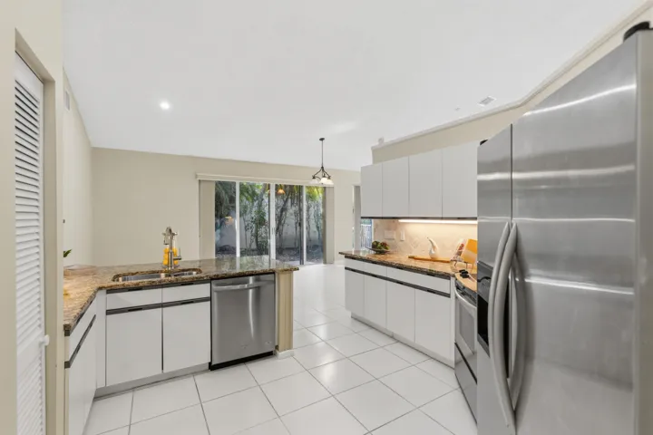Kitchen with granite countertops, stone backsplash, stainless appliances, pantry and breakfast nook.