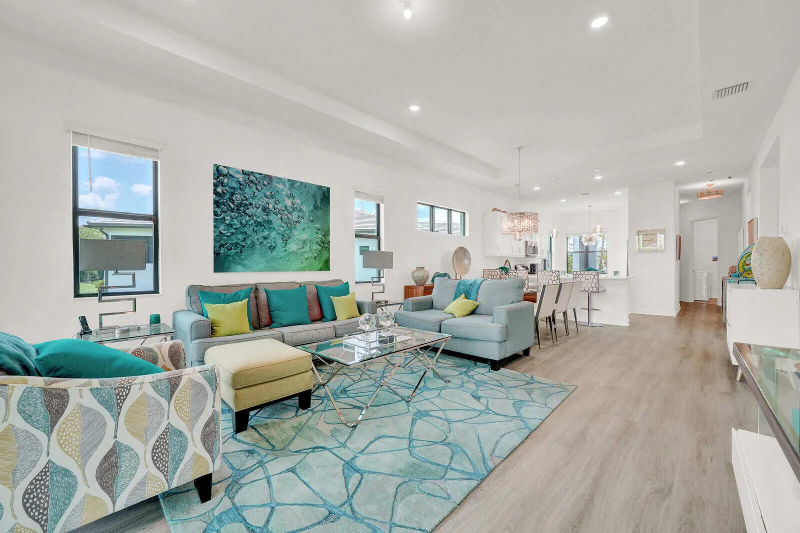 Open-concept living space featuring wood-finish flooring, recessed lighting, and high ceilings