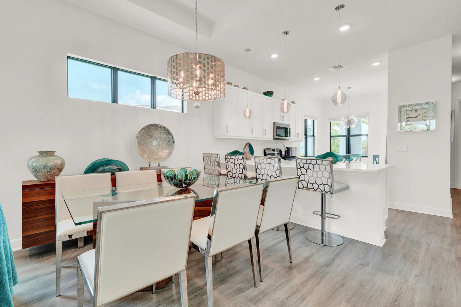 Open-concept living space featuring wood-finish flooring, a contemporary chandelier, recessed lighting, and high transom windows