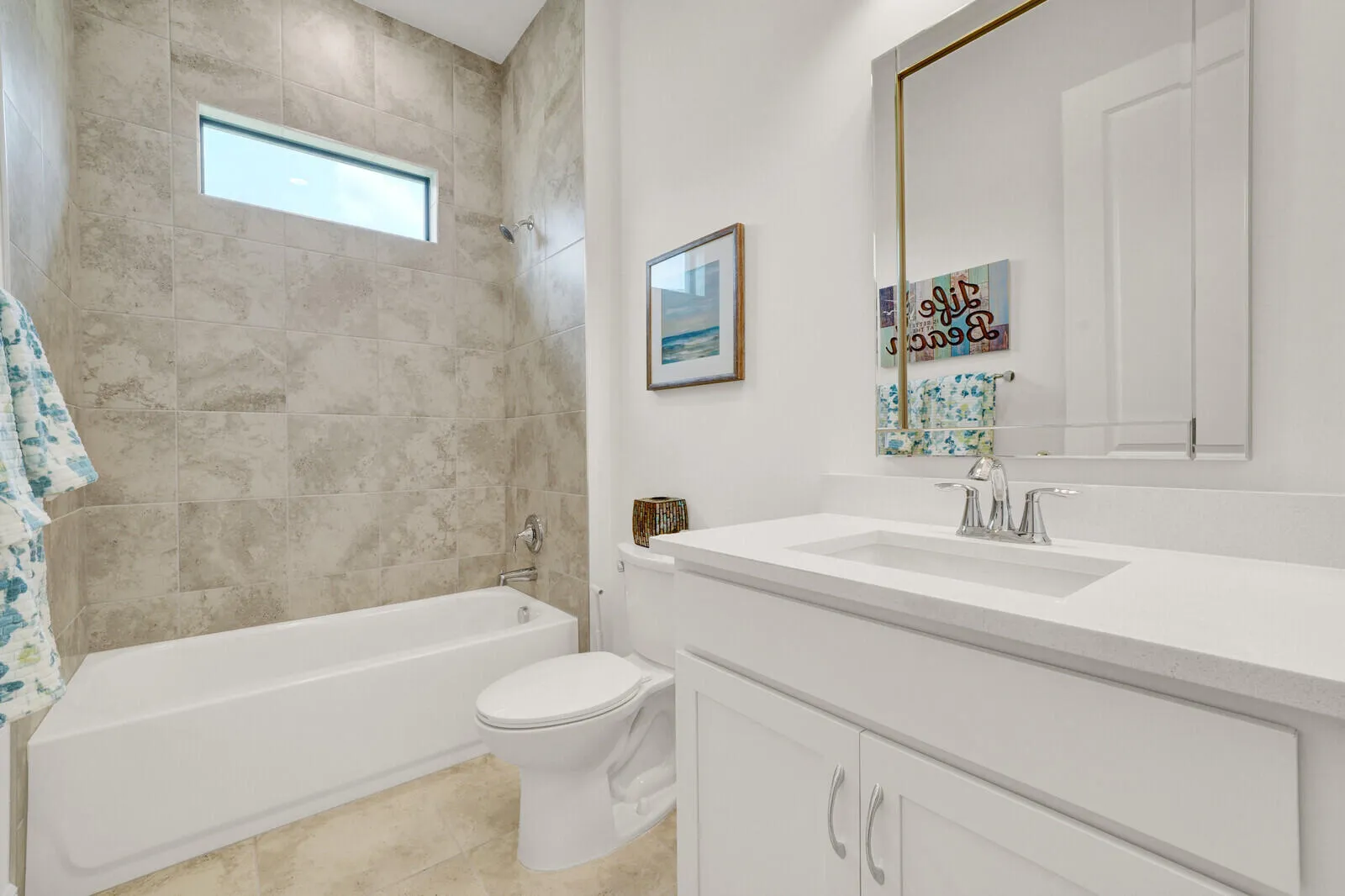 Bathroom featuring a white vanity with a light-toned countertop, an undermount sink, and a framed mirror