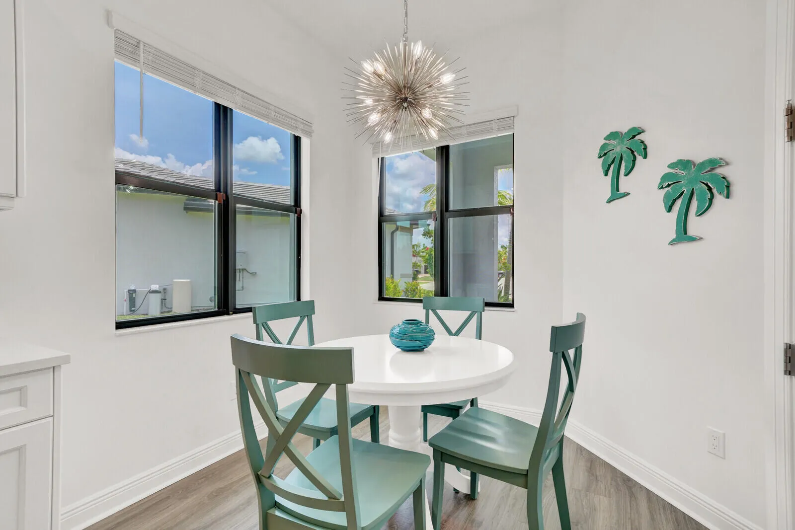 Dining area featuring white walls, wood-finish flooring, and a contemporary sputnik-style chandelier