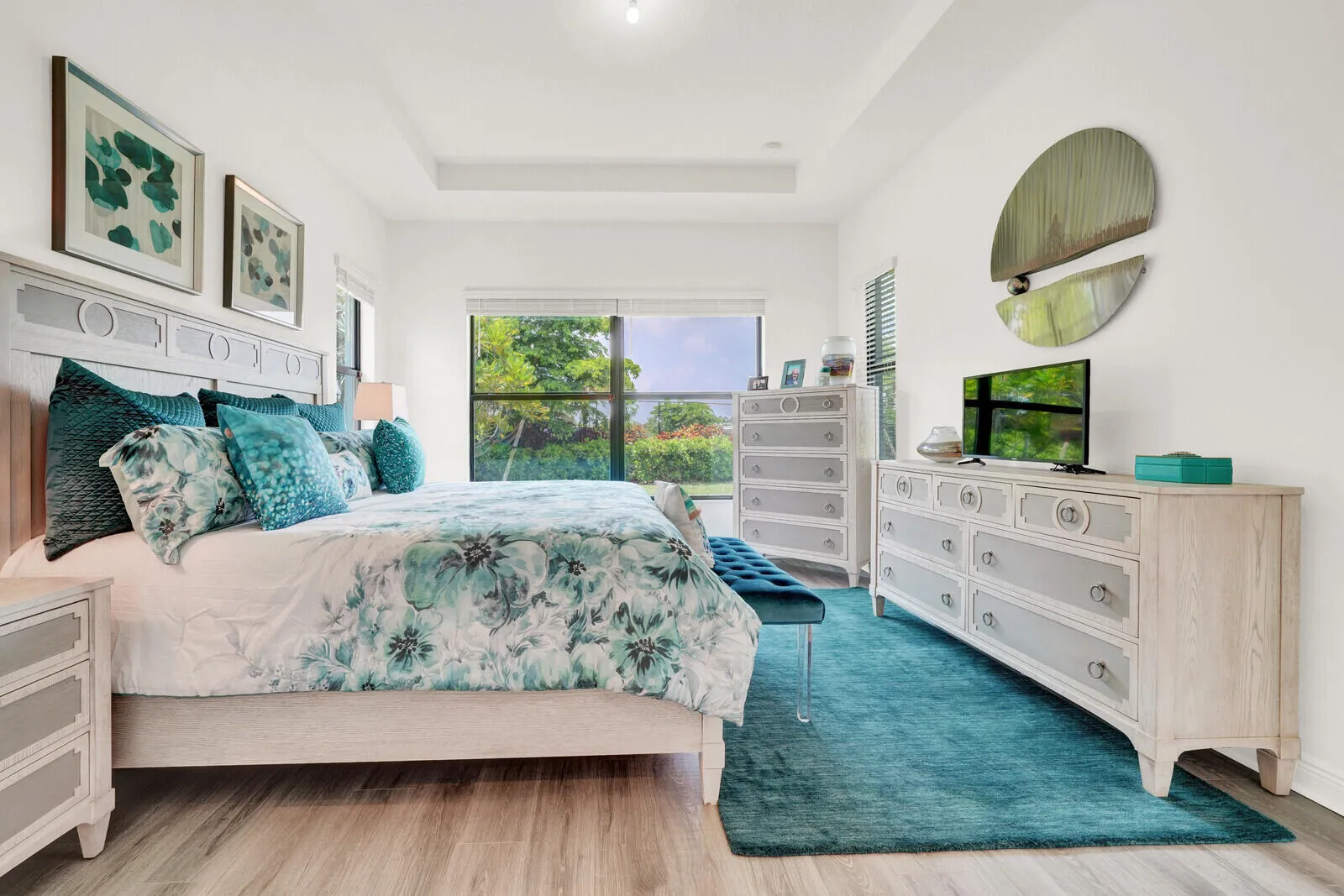 Tray ceiling with recessed lighting above wood-finish flooring
