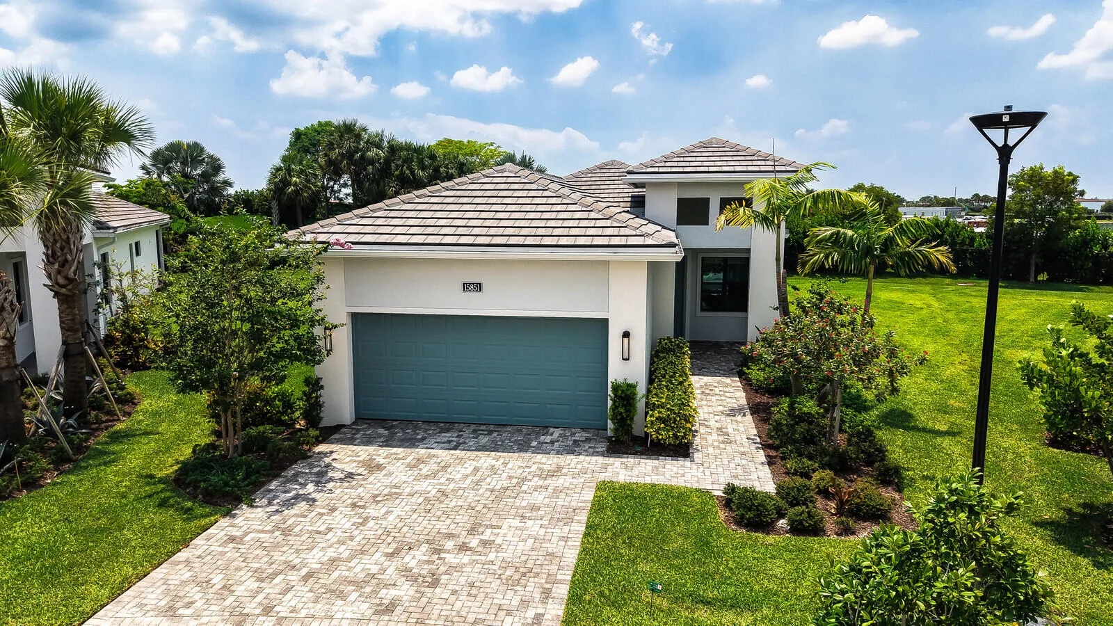 Modern architecture featuring a two-story design with a tile roof and a teal garage door