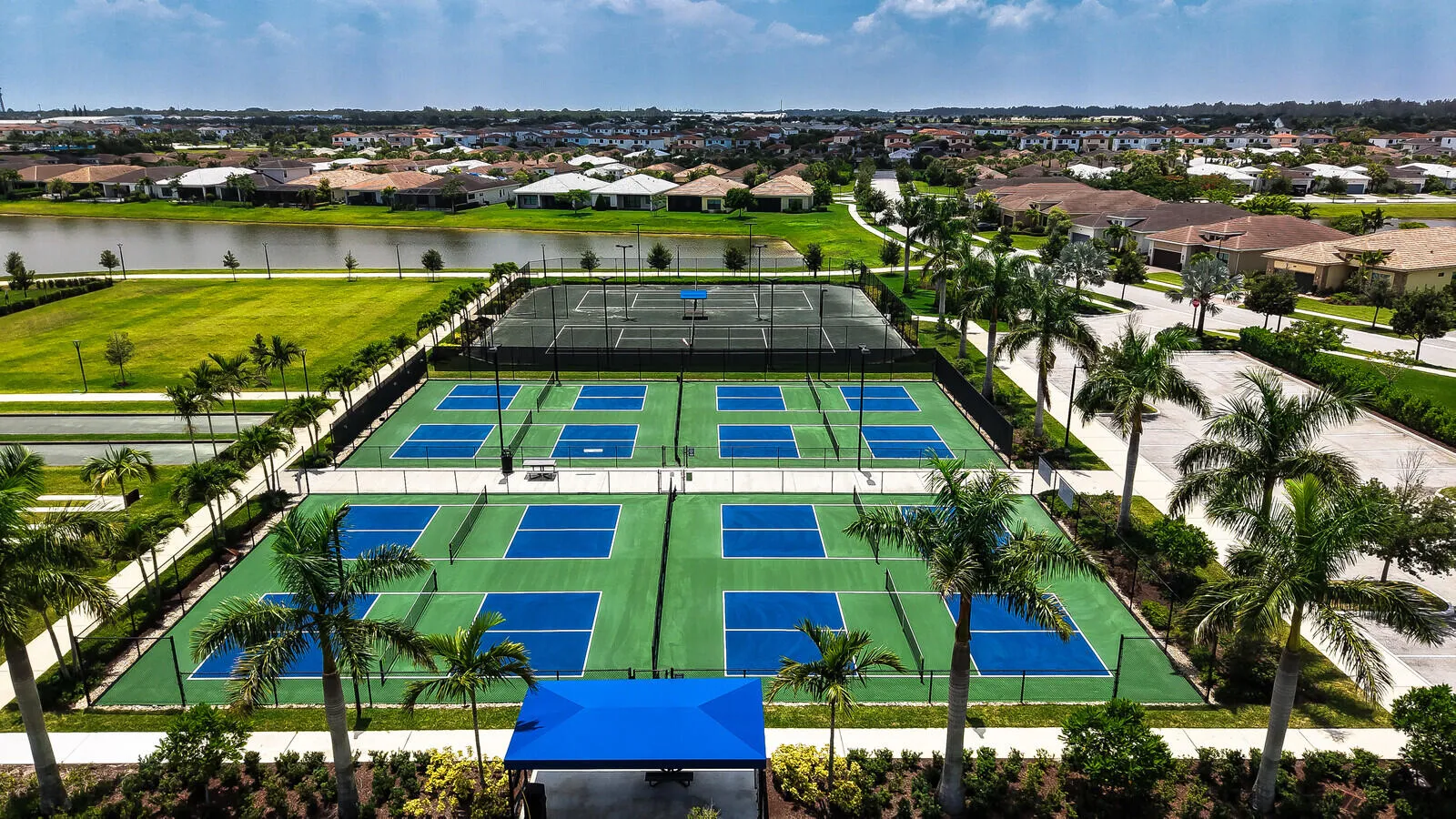 Recreational courts featuring multiple pickleball courts with blue and green surfacing and two tennis courts