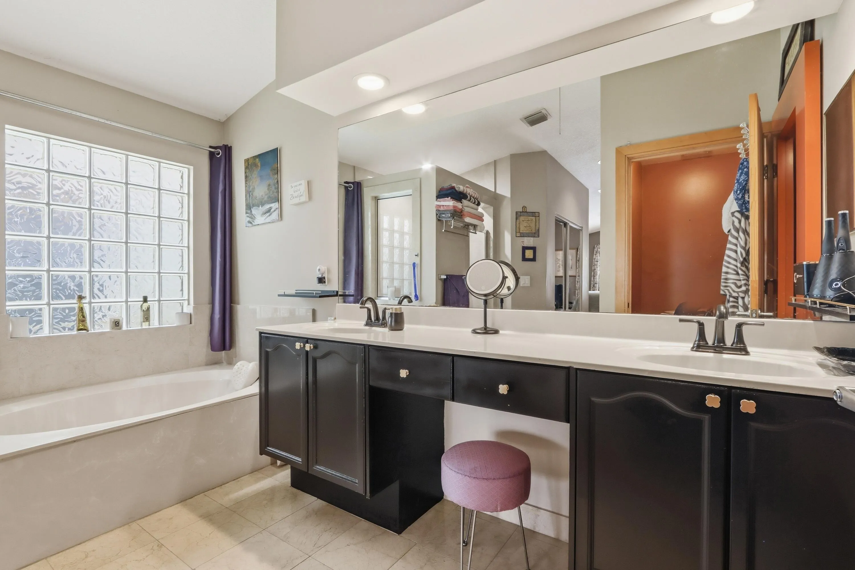 primary bathroom with deep tub and double sinks