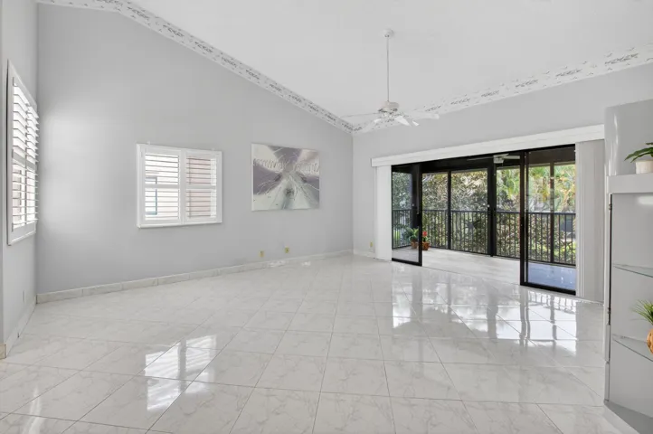 LIVING AREA OPENS TO THE ENCLOSED BALCONY WITH LOVELY GARDEN VIEW