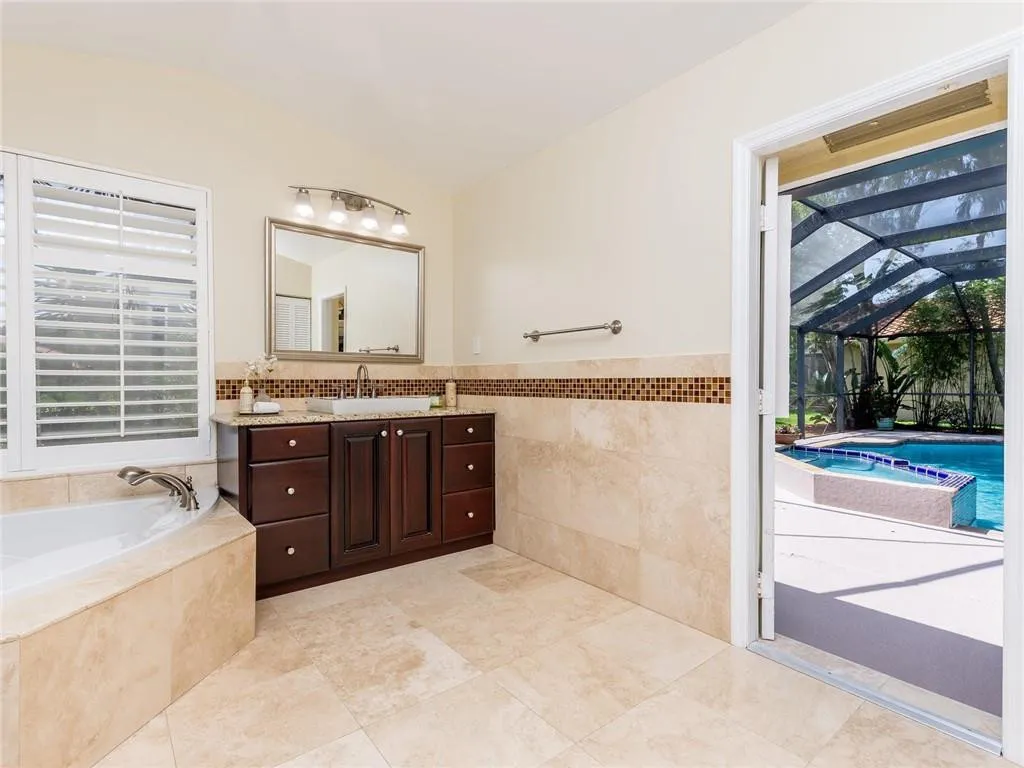 Remodeled master bath with wood cabs, granite counters, modern sinks plantation shutters, linen closet.