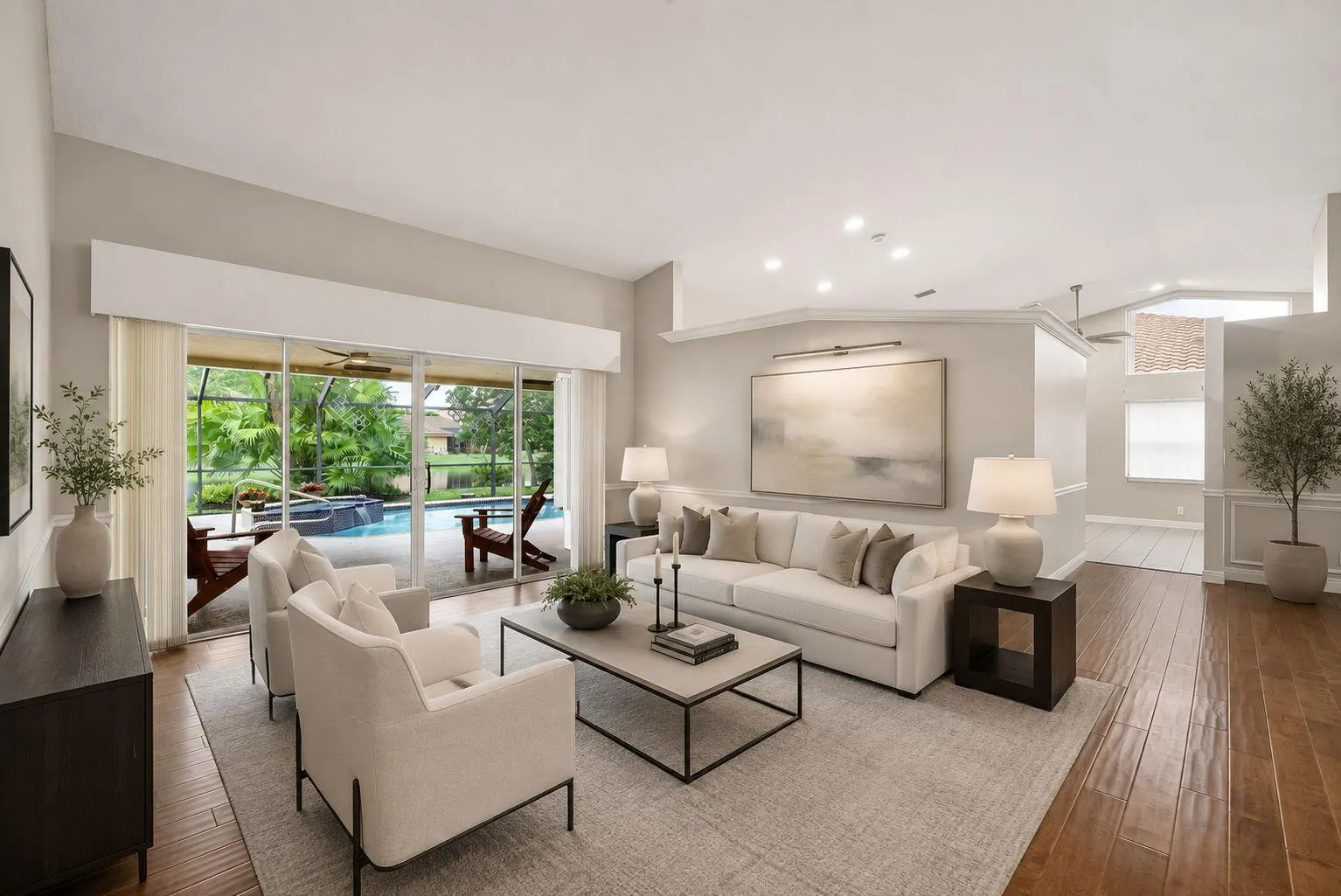 Virtually staged living room with hardwood flooring and sliding glass doors that lead to one of the two covered patio areas.