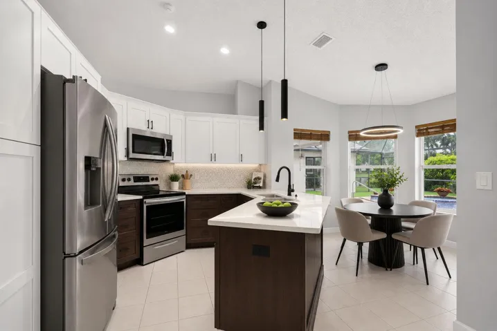 Virtually staged breakfast area. AI added black lights to kitchen, not actual.