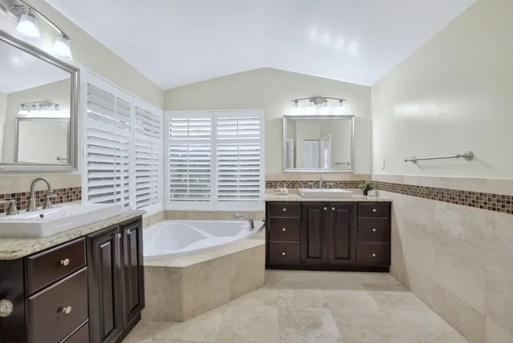 Remodeled master bath w/ dual vanities, sep tub and shower, linen closet & cabana door to pool.