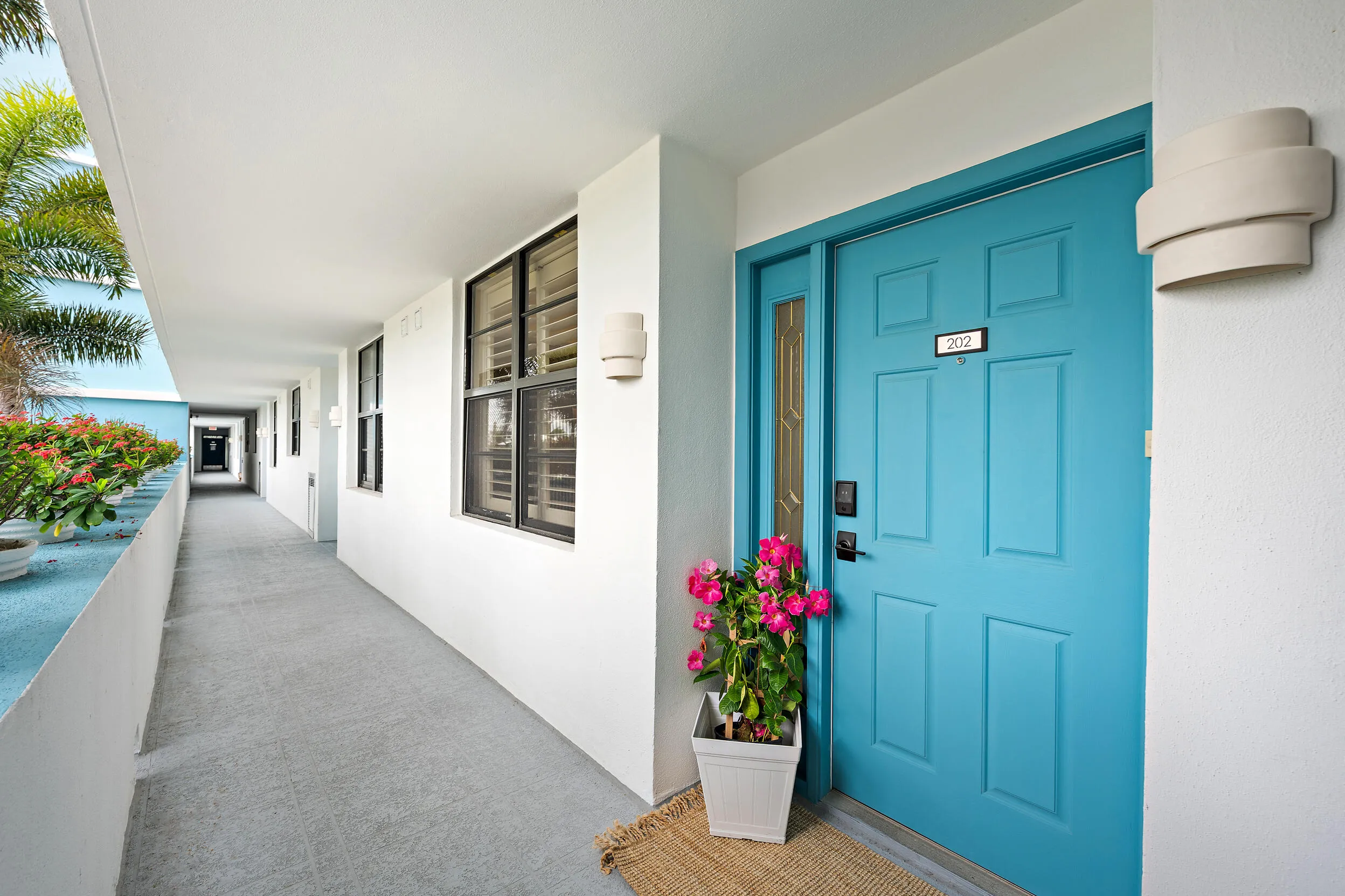 Open hallway with elevator and private storage room for unit 202