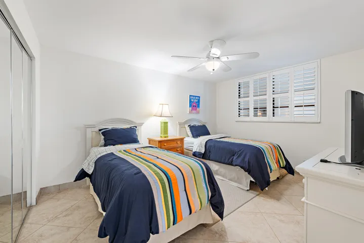 2nd bedroom with plantation shutters, tile flooring and closet space
