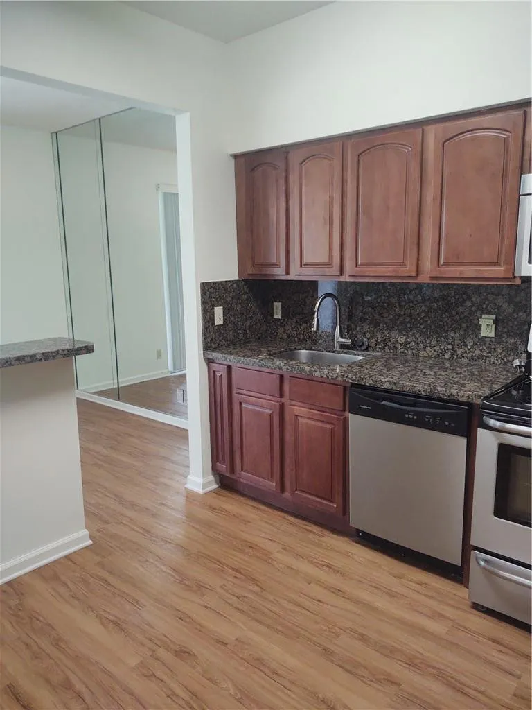 Renovated Kitchen with granite counters, wooden cabinets and stainless appliances.