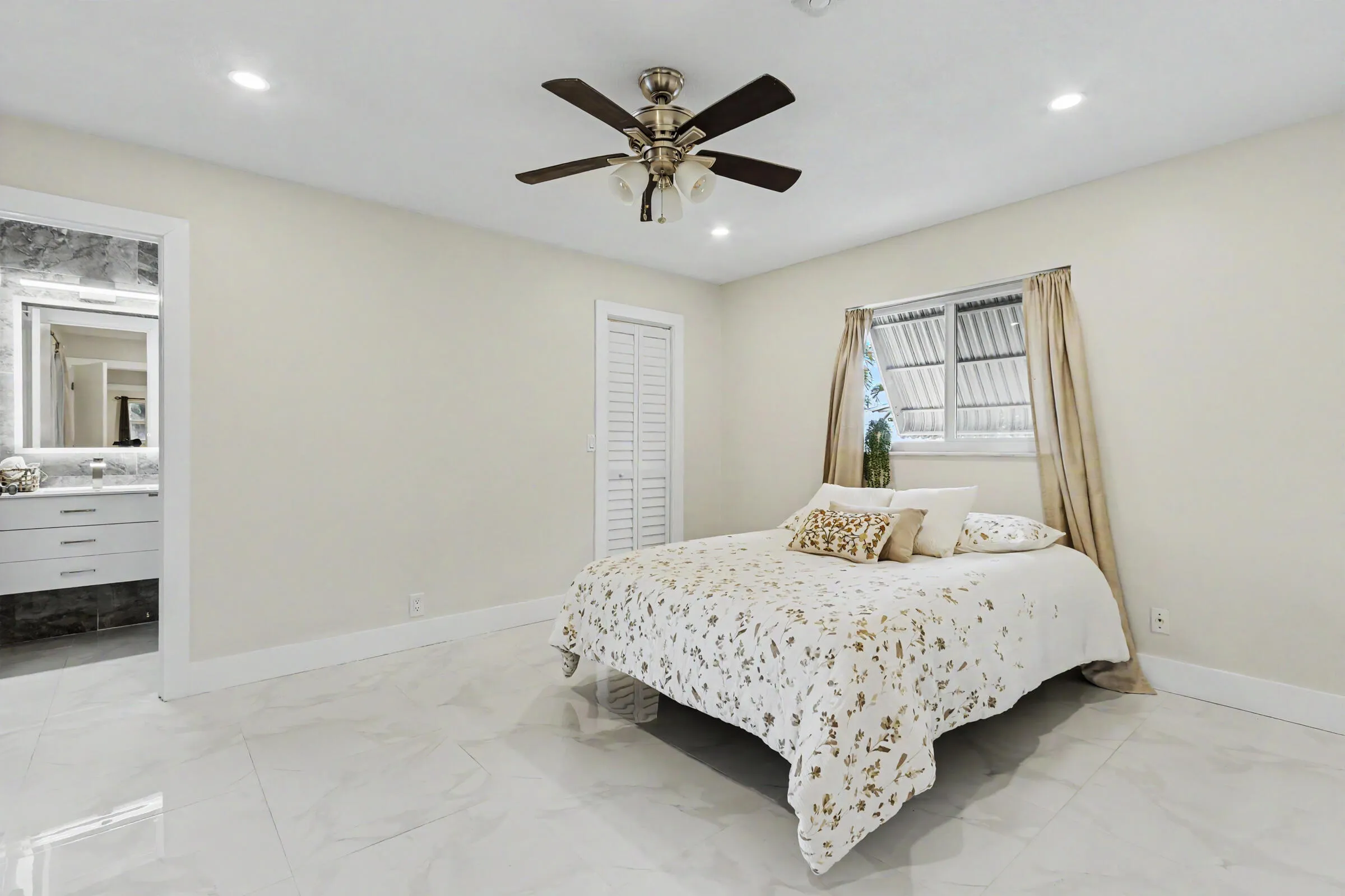Primary bedroom with an en suite bathroom and walk in closet.