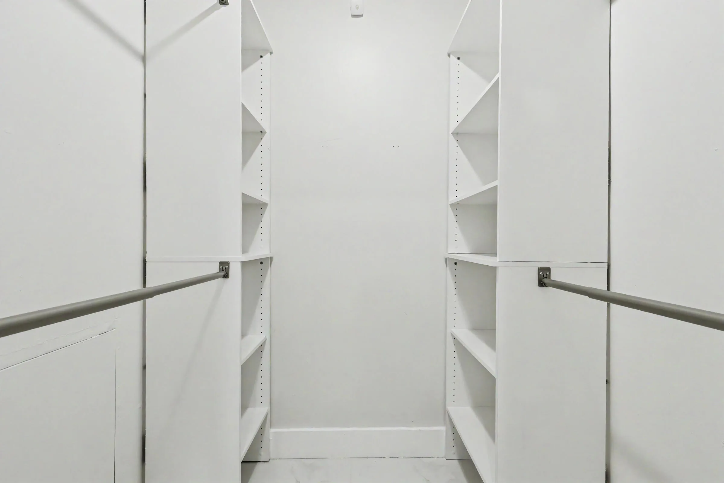 Primary closet with built in storage and a floor safe