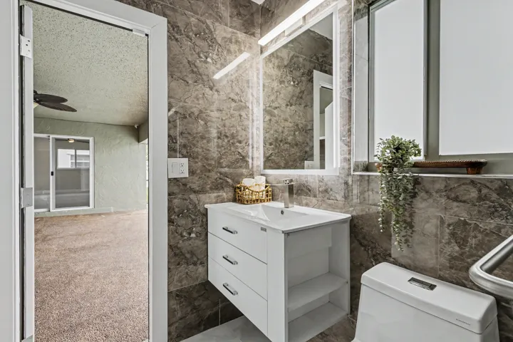 Primary bath serves as a cabana bath with direct access to the patio/pool area.