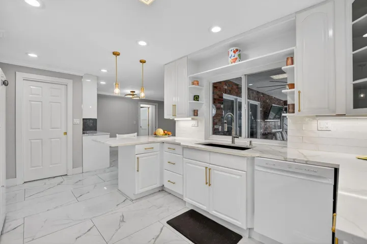 Sparkling quartz countertops with full subway backsplash, deep farmhouse sink and pass thru to the covered patio!