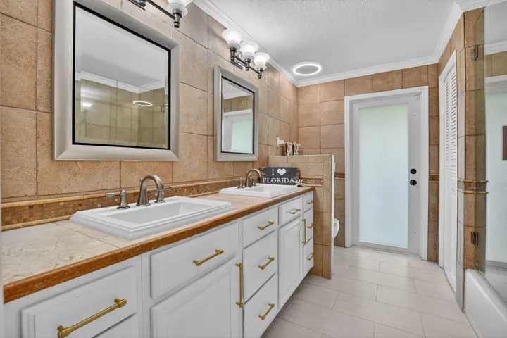 Guest bath shines with a new frameless shower/tub combination boasting tile to the ceiling and pretty inlays.