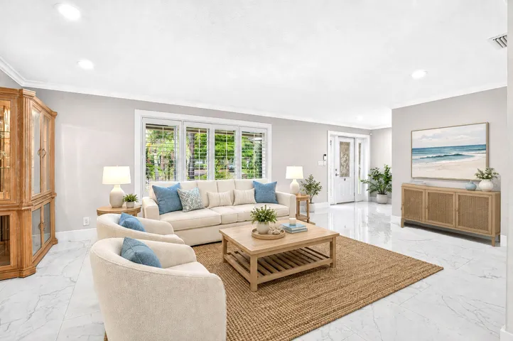 Oversized living room with Plantation shutters overlooking lush landscaping.