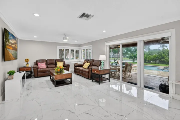 Sip a cool drink and relax with guests in your OVERSIZED family room opening to the 25x10 screened patio with beautiful travertine flooring.