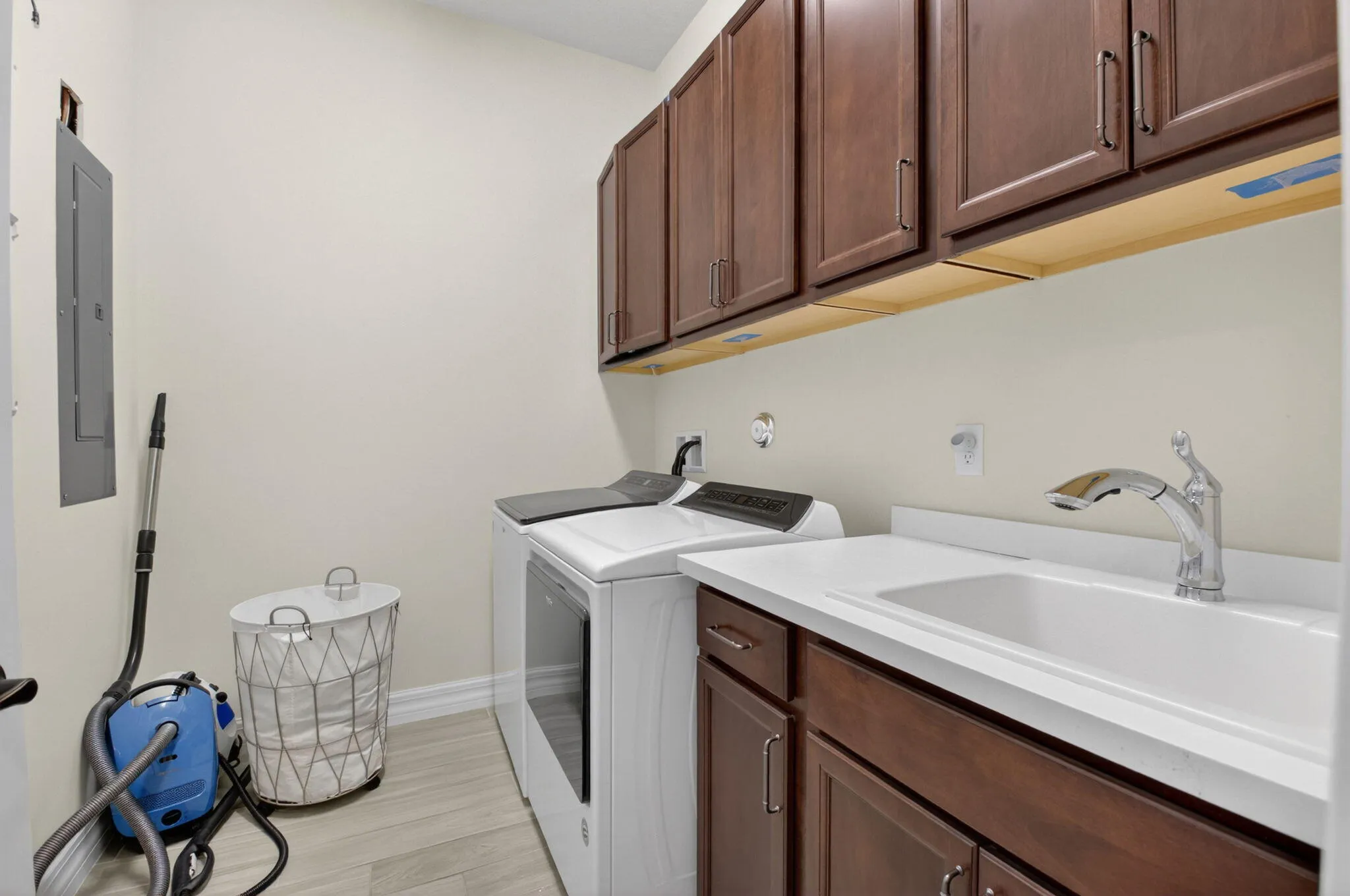 Large laundry room with ample amounts of storage and utility sink