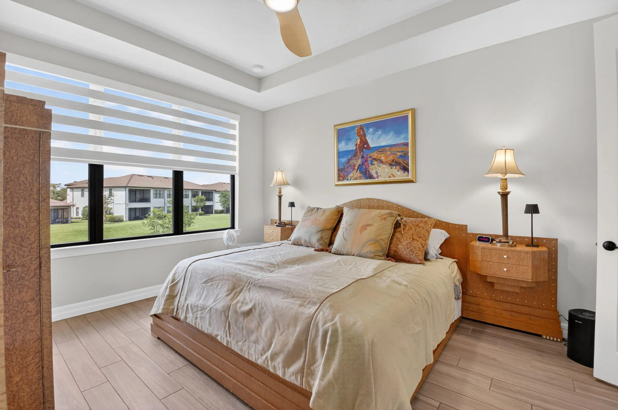 Primary bedroom with trey ceiling, lake views, en suite, and custom walk-in closet.